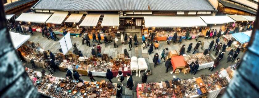 photograph showcasing a wide-angle view of a flea market in Kyoto, bustling with people browsing through stalls filled with antiques